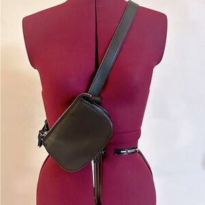 Small cross body purse/fanny pack. Black with brass hardware.